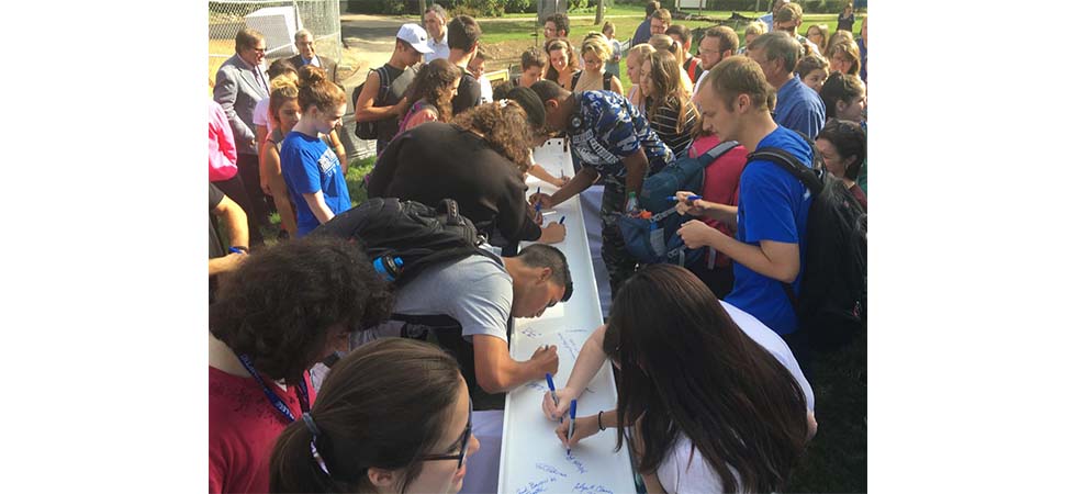 Hundreds Sign Beam in Celebration of Construction Milestone of New Academic Building