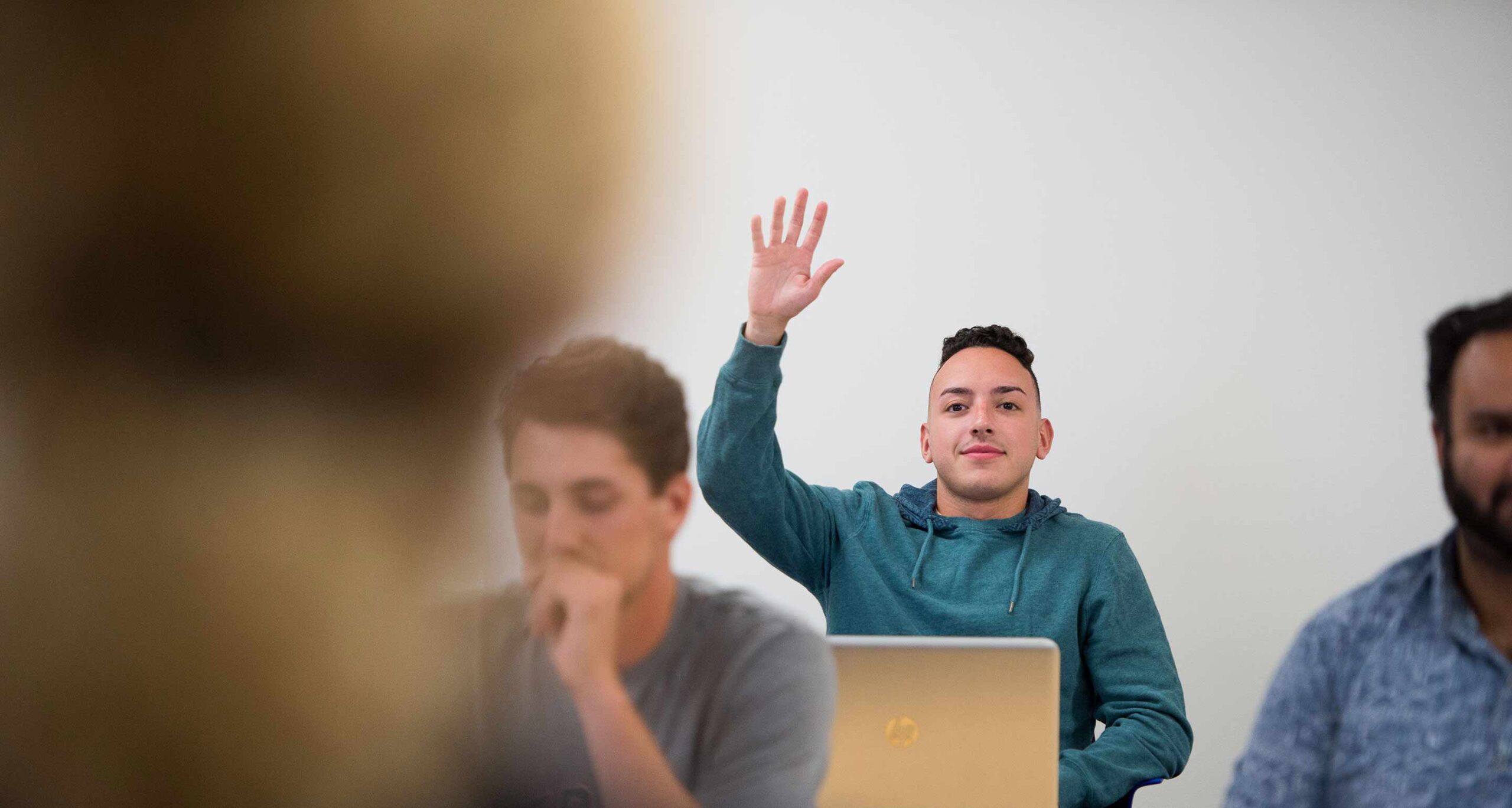 student raising hand in class