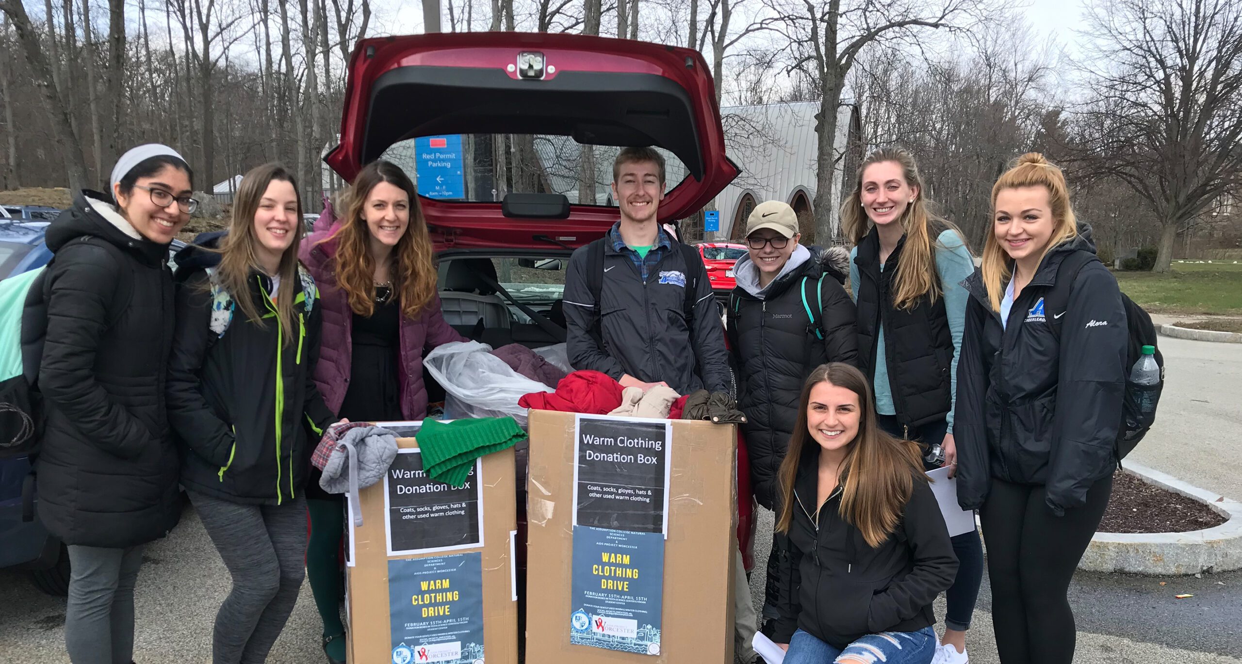 A group of Assumption College students displaying the warm clothing they collected for the needy through a coat drive.