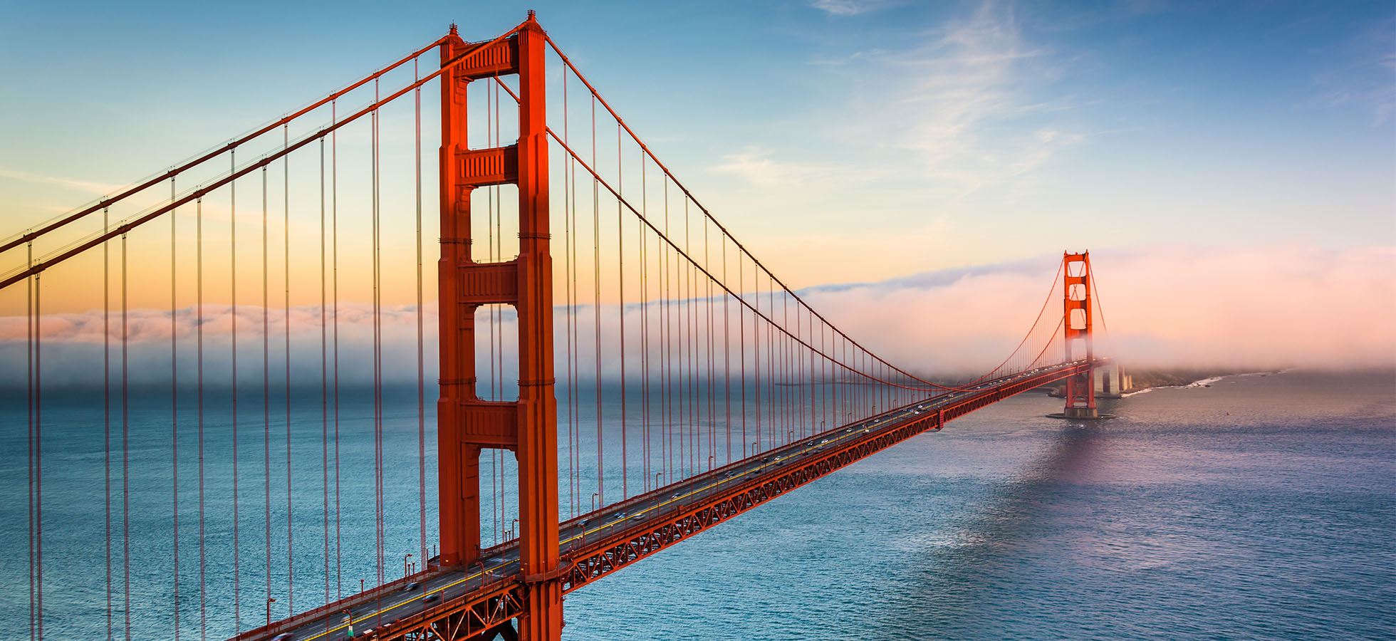 A photo of the Golden Gate Bridge at sunrise.