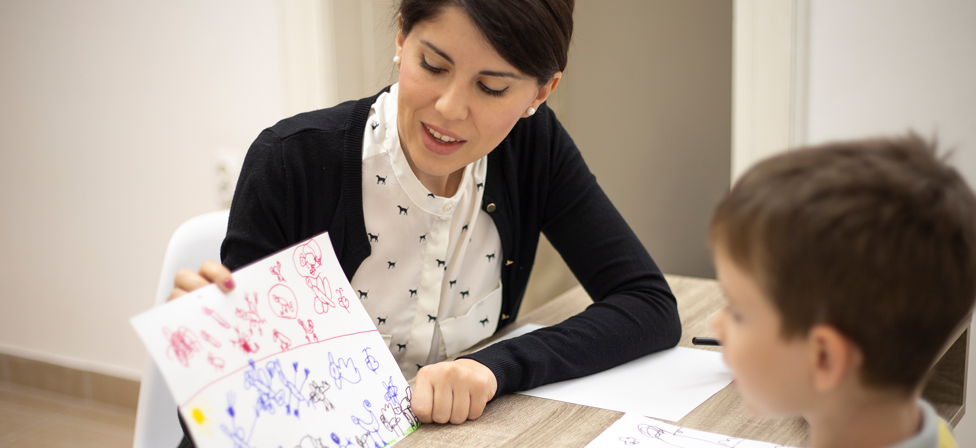 Photo of a teacher working with a child. Assumption offers a Master's in Applied Behavioral Analysis so that students may learn the science of behavior to influence change and solve socially significant problems.