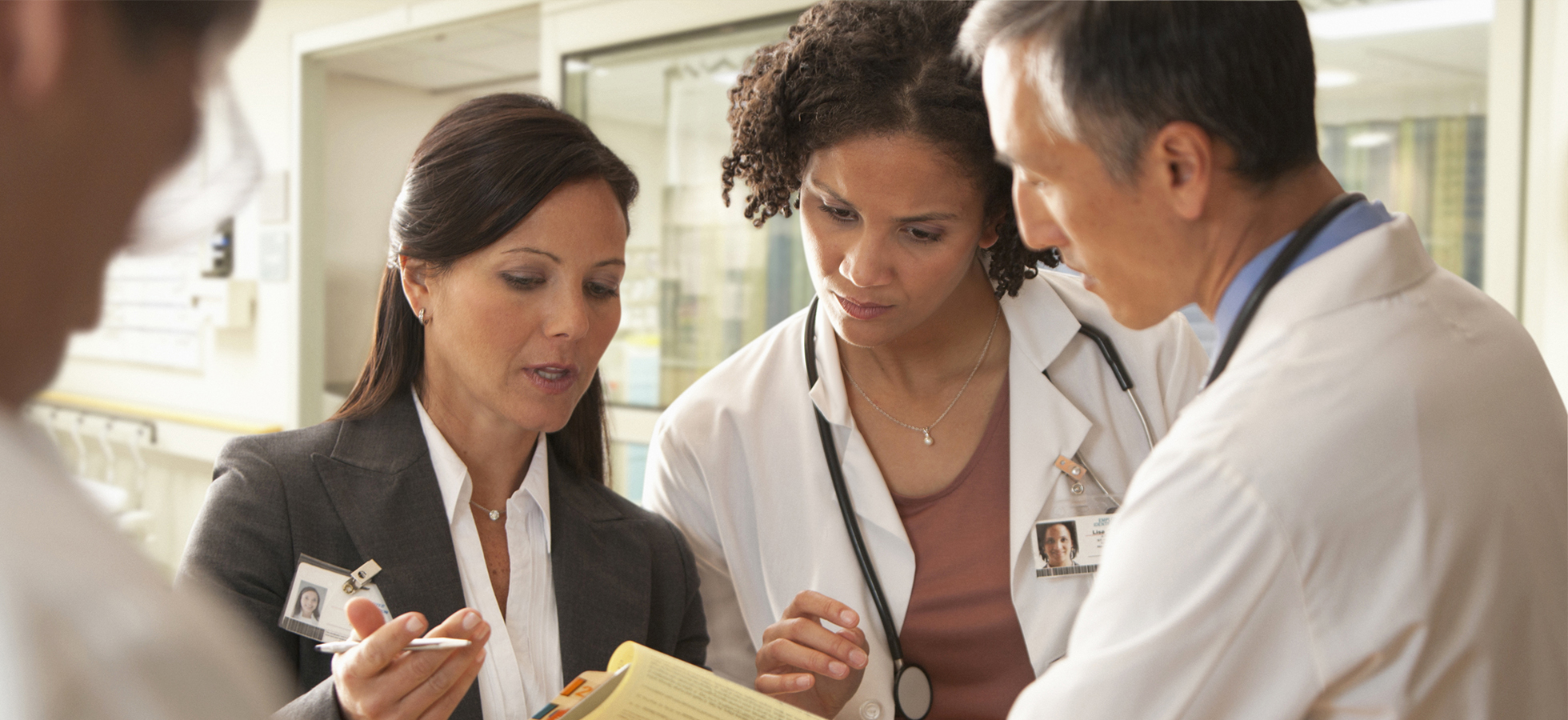 Photo of health professionals conferring about a patient. Assumption's Health Advocacy Program includes elements of management, social sciences, human services, education and health science in such a way to prepare students to become effective professionals