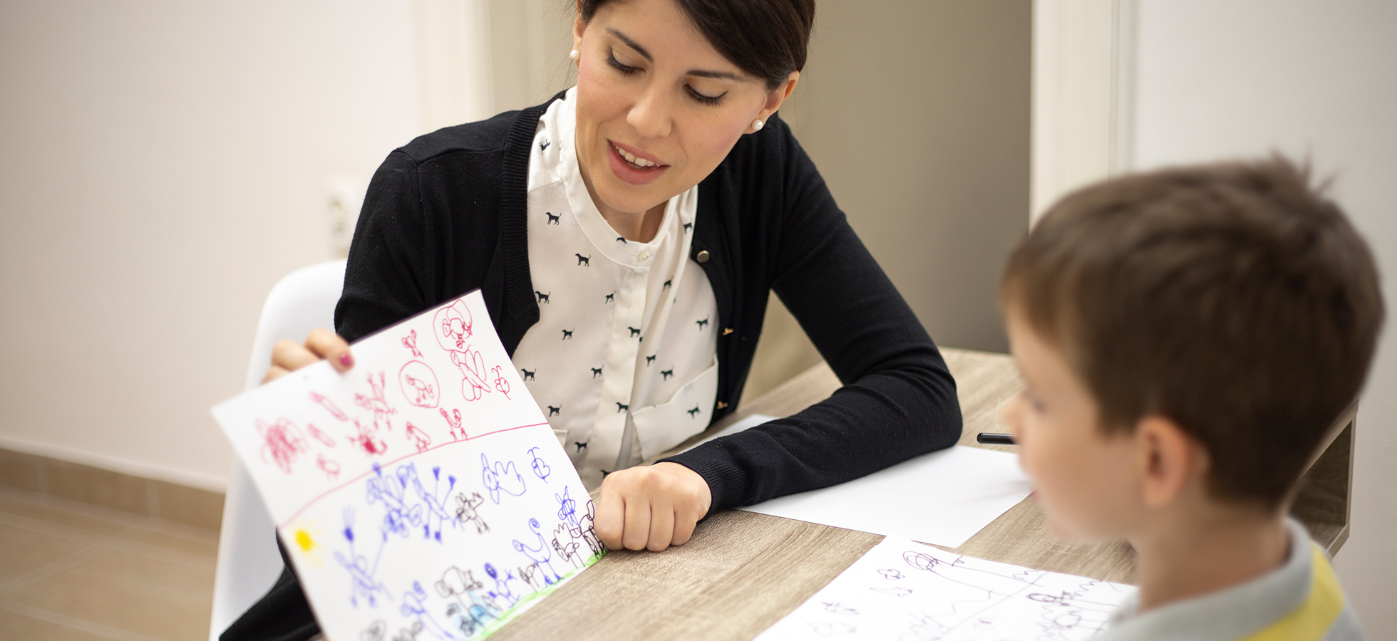 A teacher working with a student. Assumption's Applied Behavioral Analysis program prepares teachers to effectively work with students.