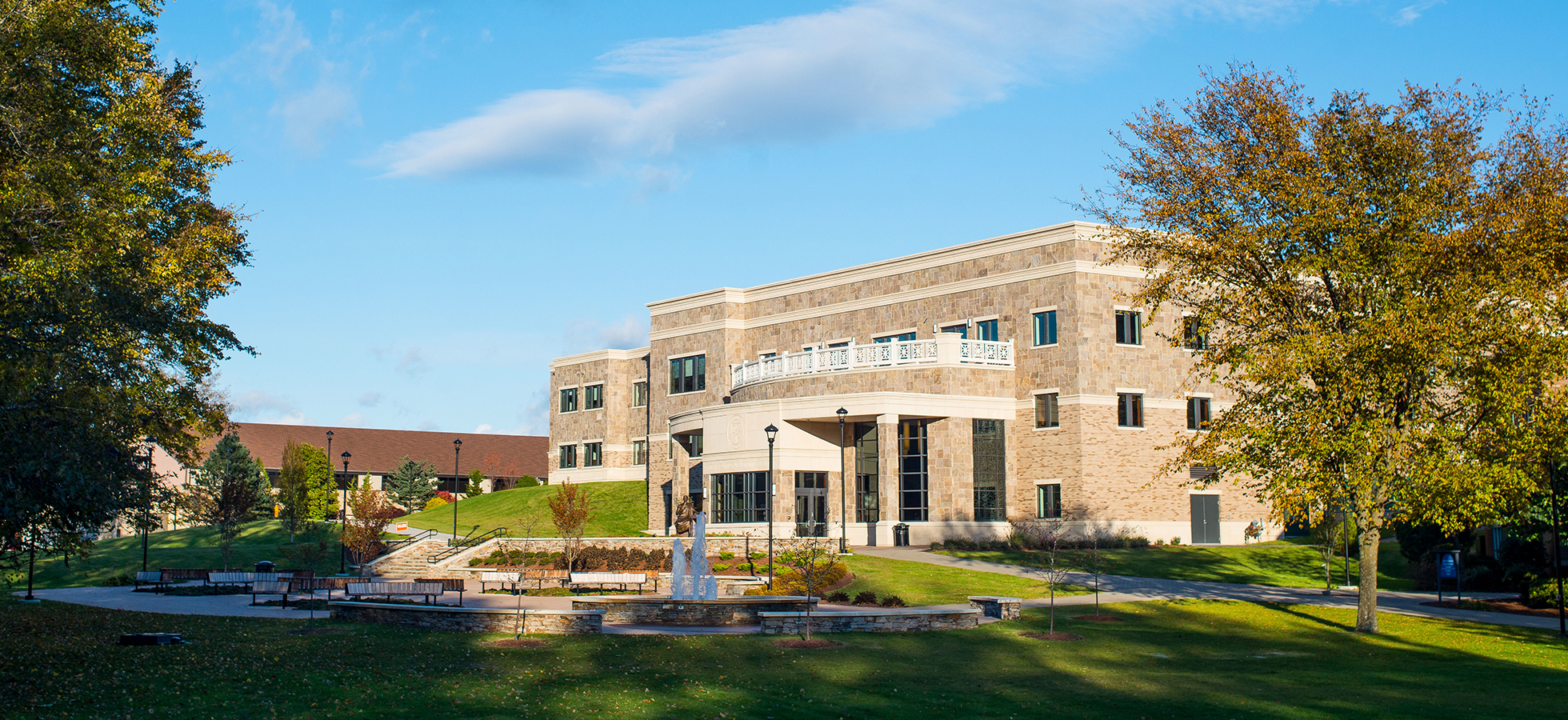 Assumption students sit outside of the new Tsotsis Family Academic Center.