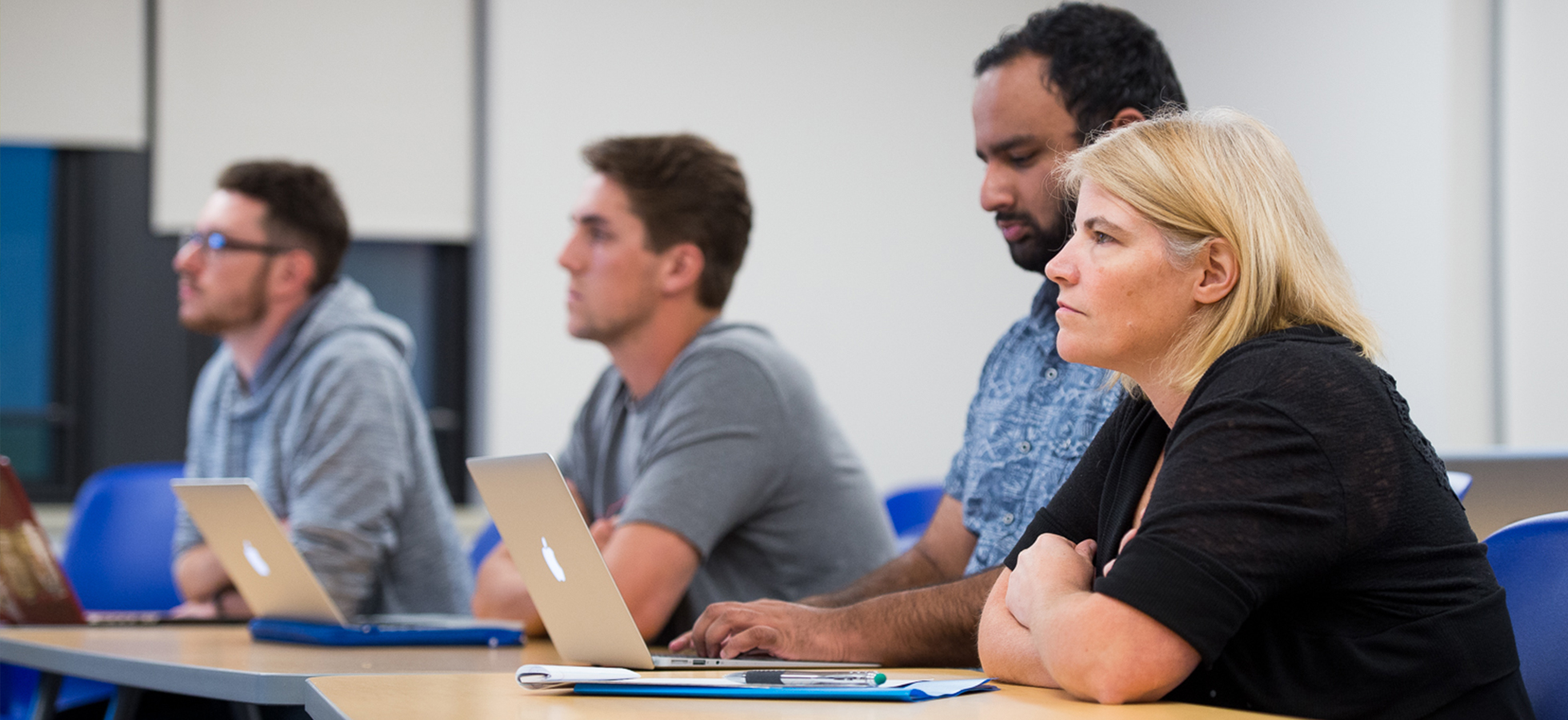 A photo of several individuals sitting at a table to promote Assumption's MBA program.