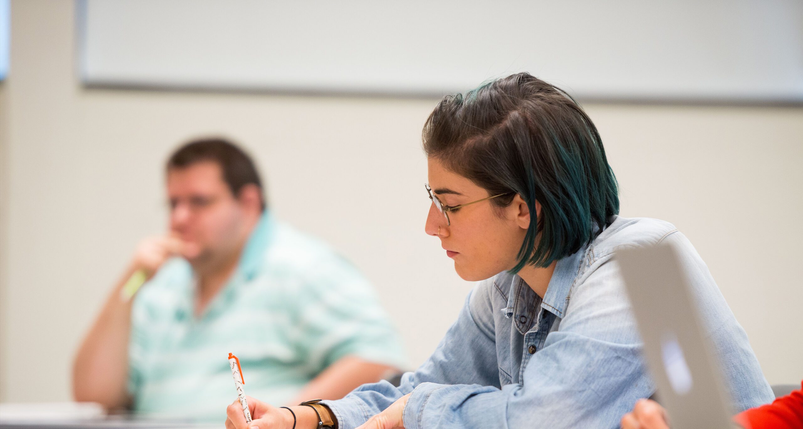 A student in Assumption University's premier graduate-level clinical counseling psychology program that specializes in Cognitive Behavioral Therapy studying in a classroom..