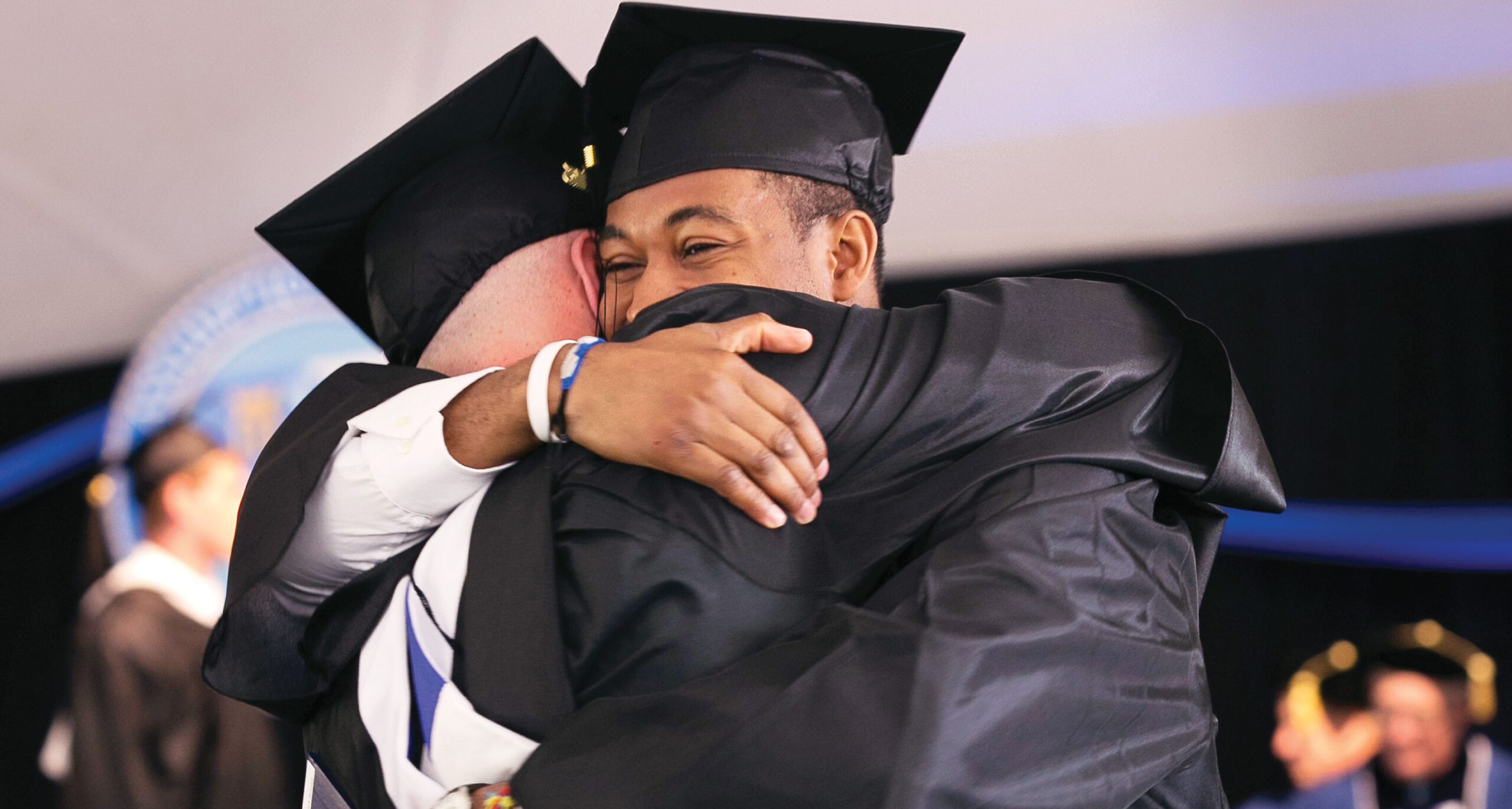 Male Graduates hugging