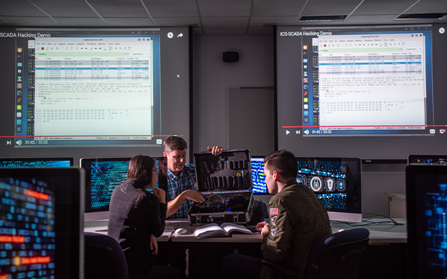 Students working with a professor in computer lab.