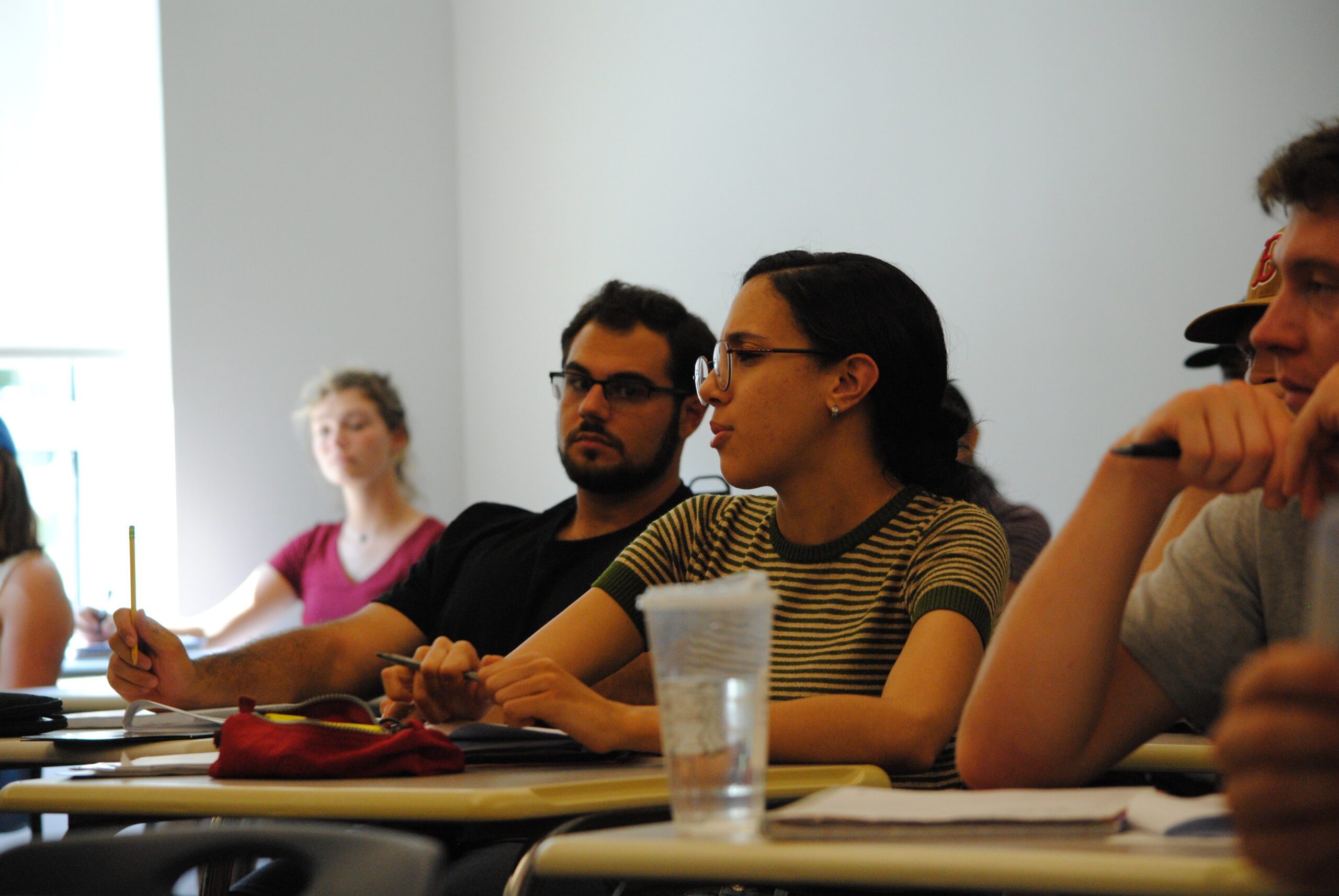 Students sitting in a classroom with their laptops open.