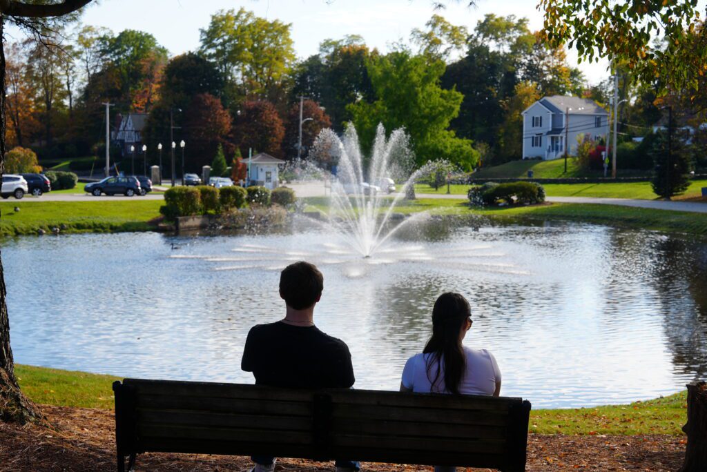 Two Assumption University students look out at the fountain on campus.