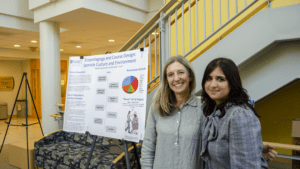 A student and faculty member standing in front of a research poster. 