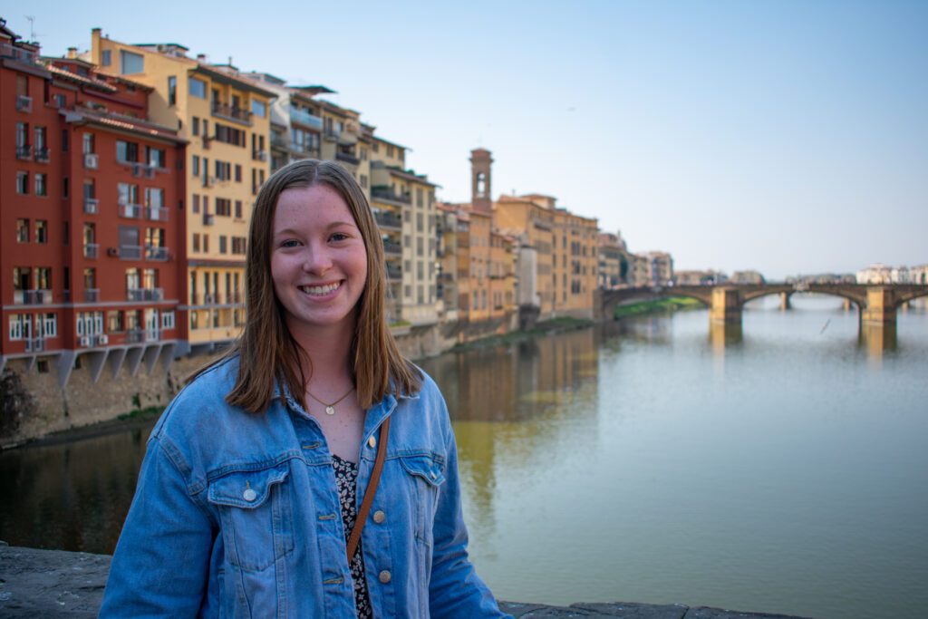 Female student standing by a bridge in Italy