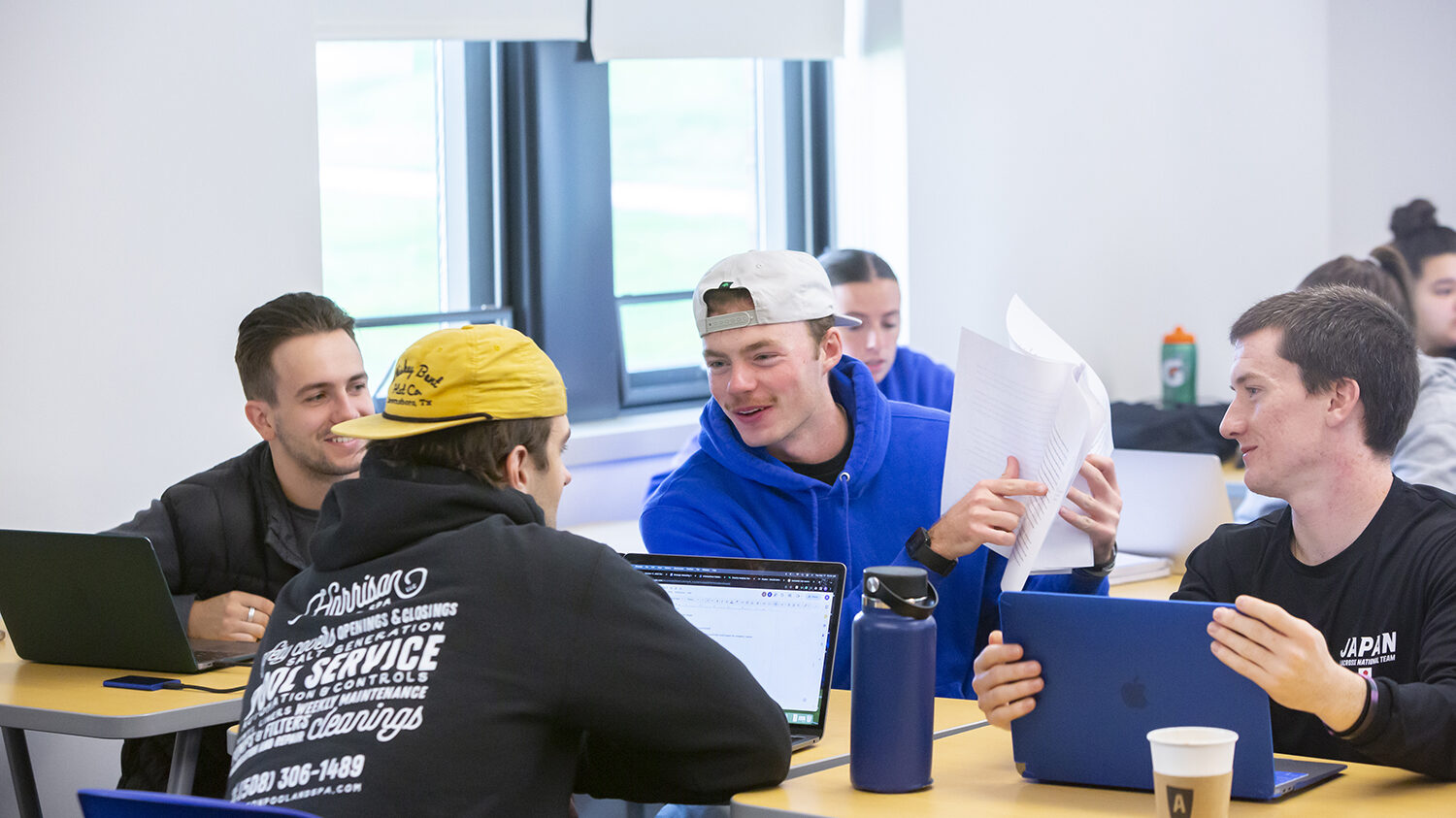 Group of male students in a classroom working together.