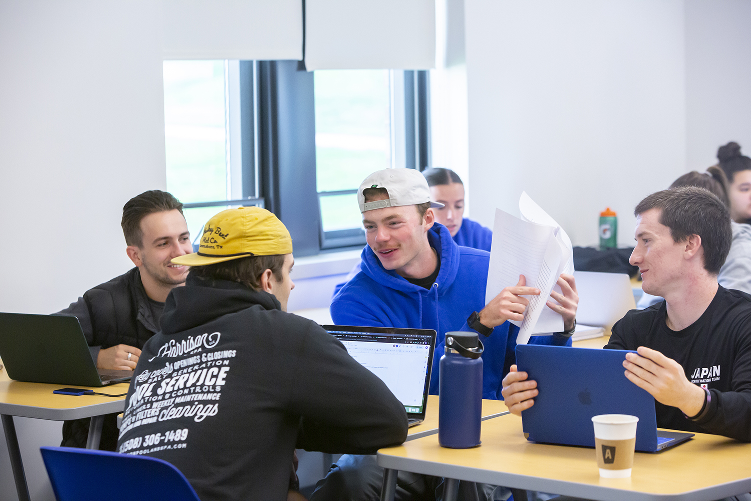 Group of male students in a classroom working together.