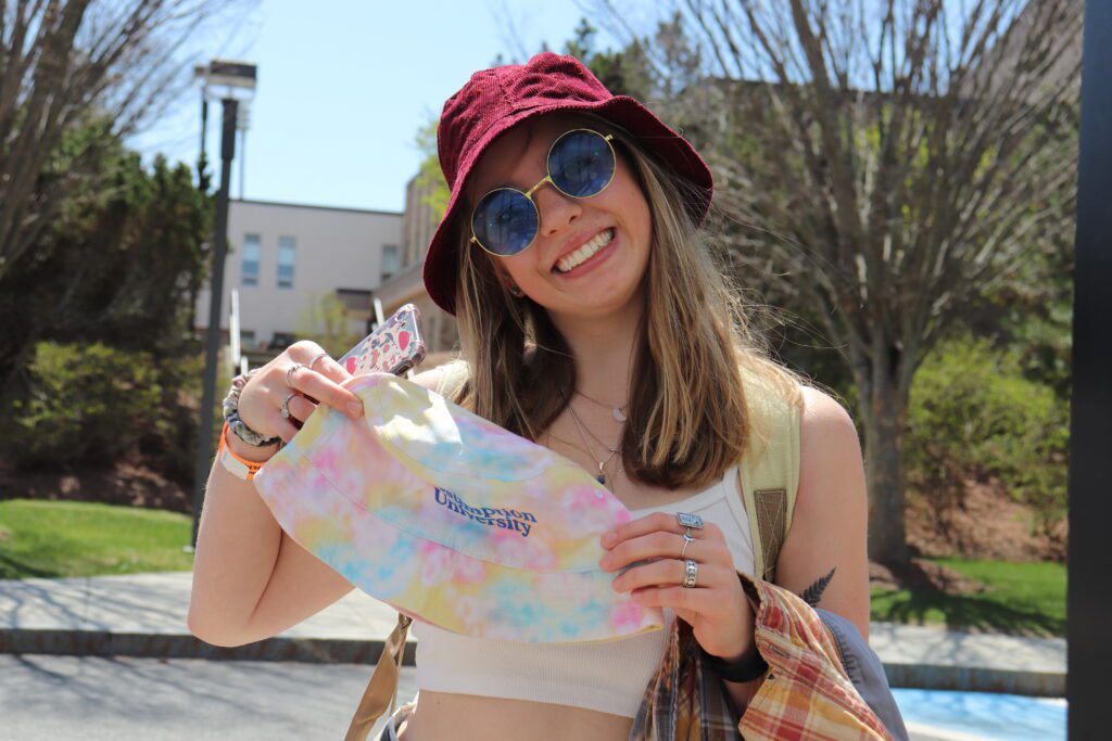 Assumption student holds up an Assumption University bucket hat