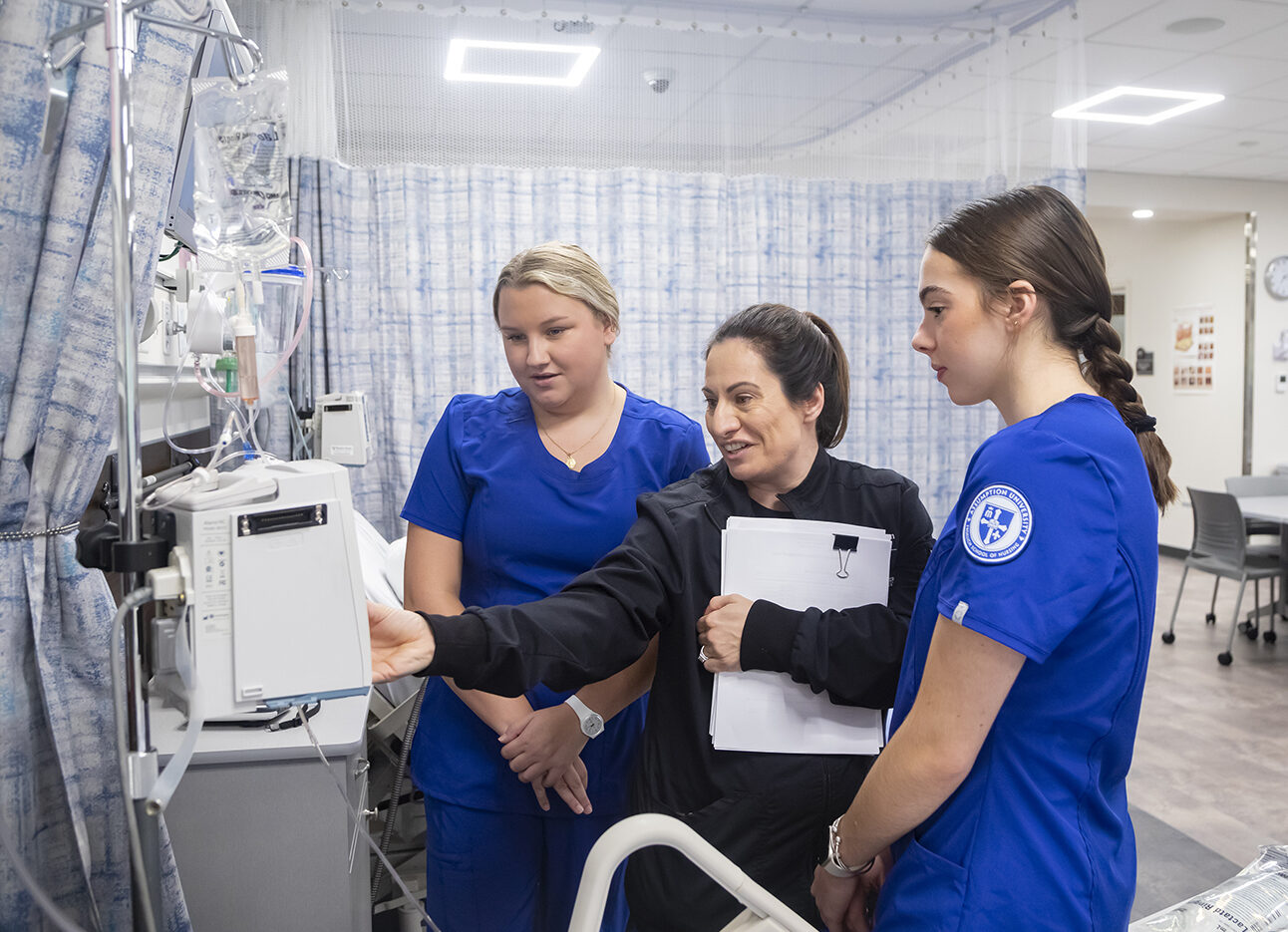 Nursing students working with a professor