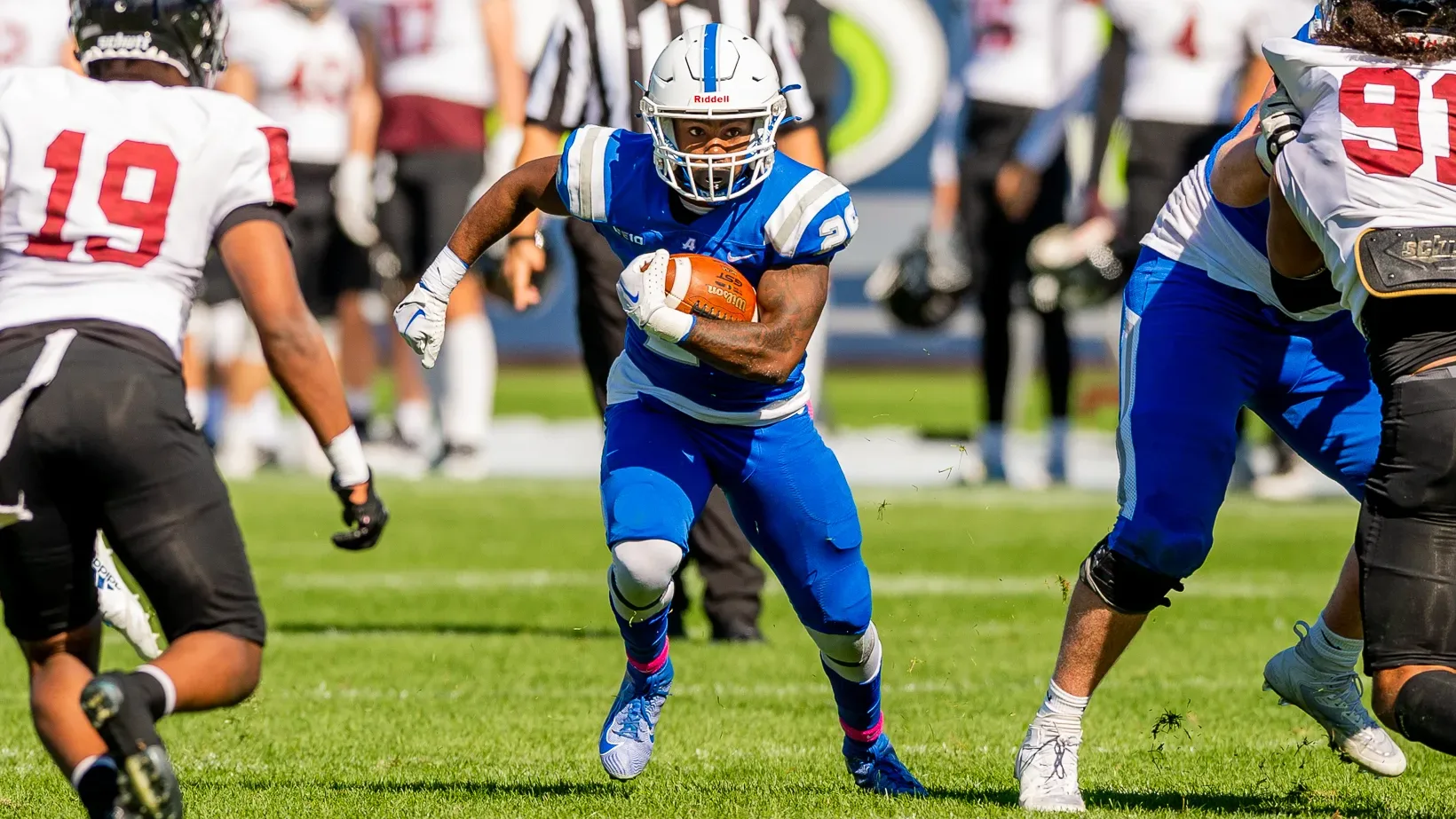 Assumption University football player runs the ball